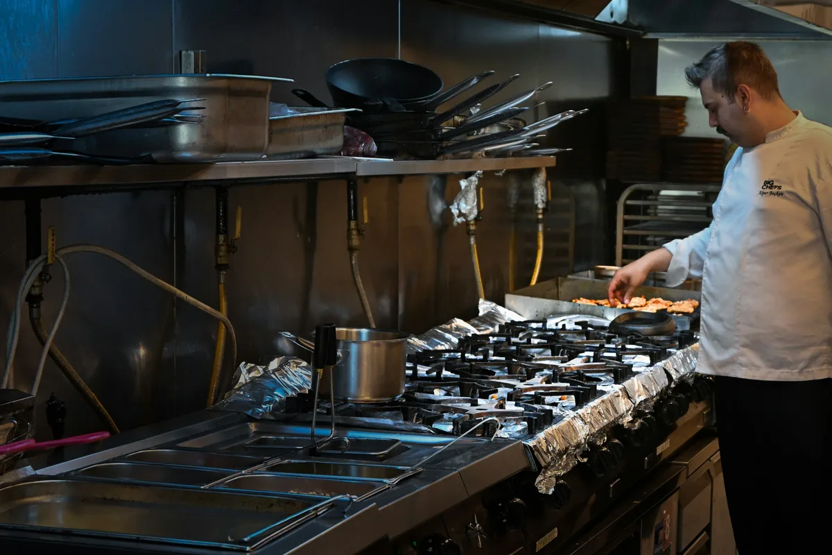 A chef cooking in a commercial kitchen — professional food preparation environment